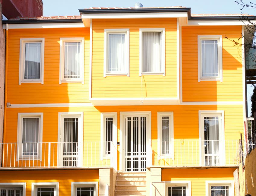 Painted house wall with windows in daylight